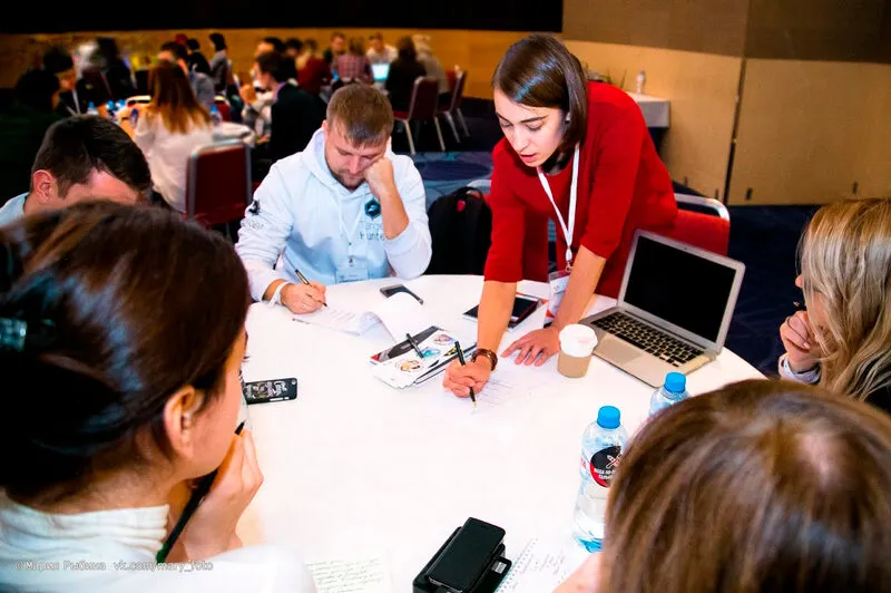 Trainer working with participants at a round table during a workshop