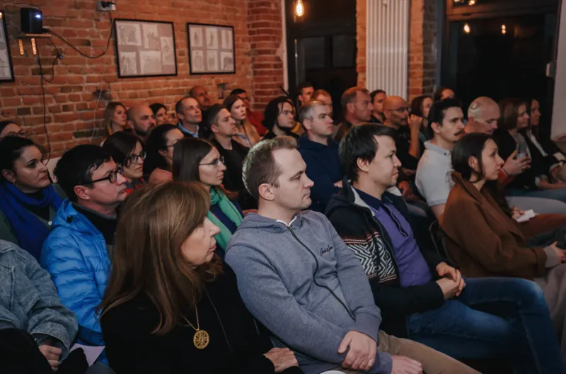 Audience at a keynote speech in a brick-walled hall