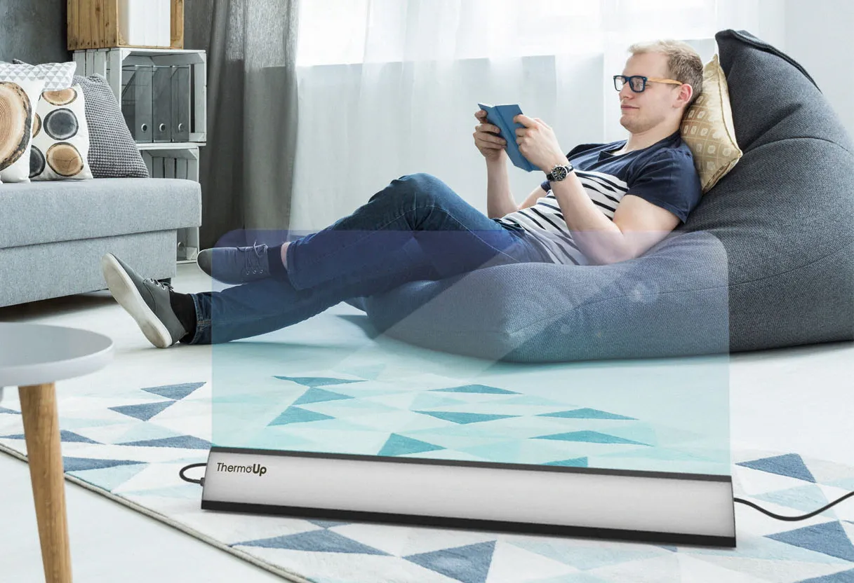 Man relaxing in a living room with a ThermoUp heater